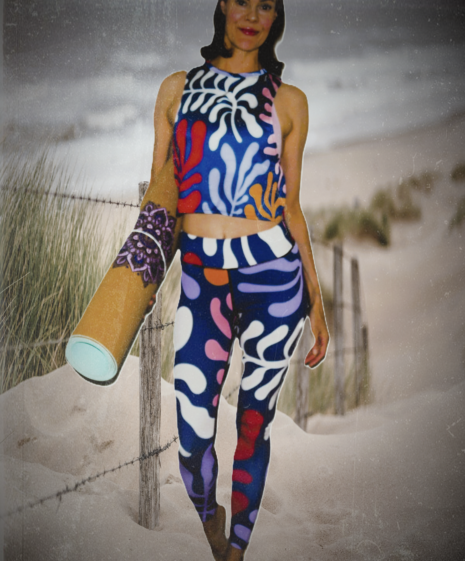 The creator of Any Origin wearing a retro flow set and holding a yoga mat by the seaside.